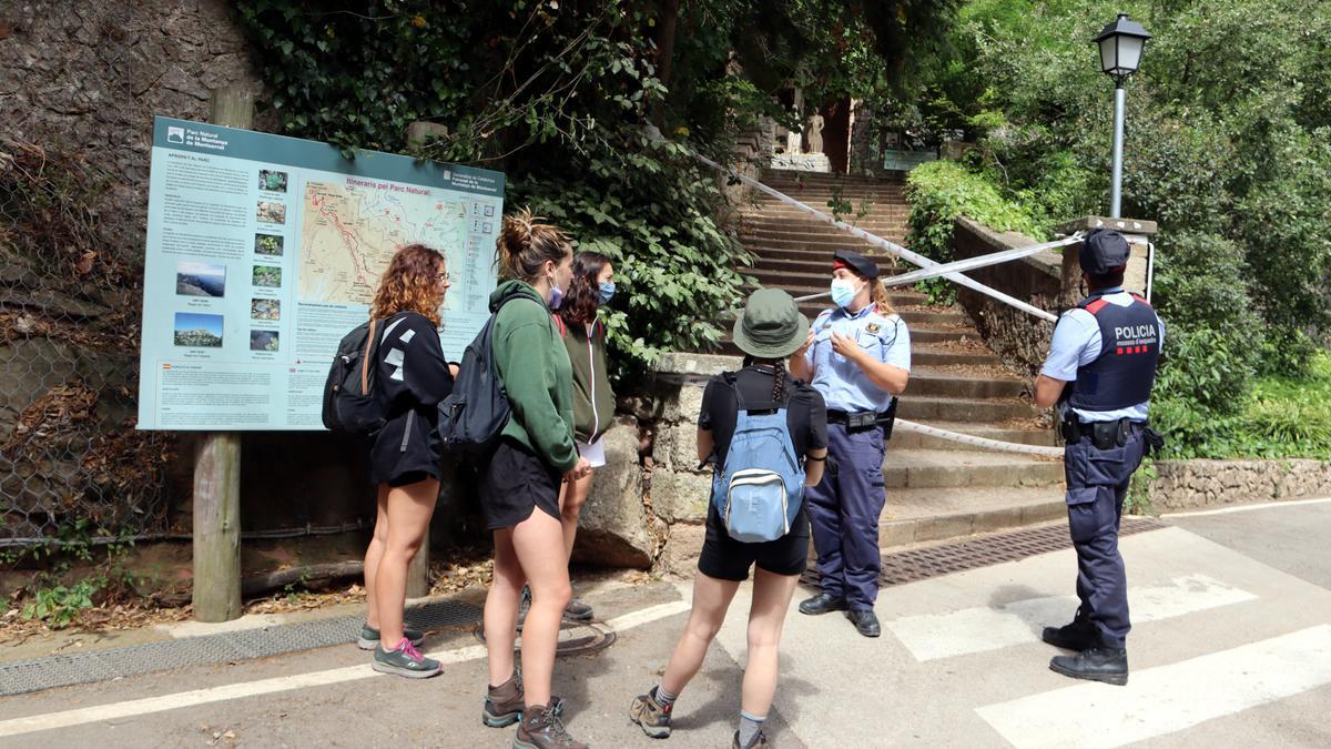 Una parella de Mossos informen a un grup de noies que volien fer una excursió que no poden entrar al Parc Natural de Montserrat