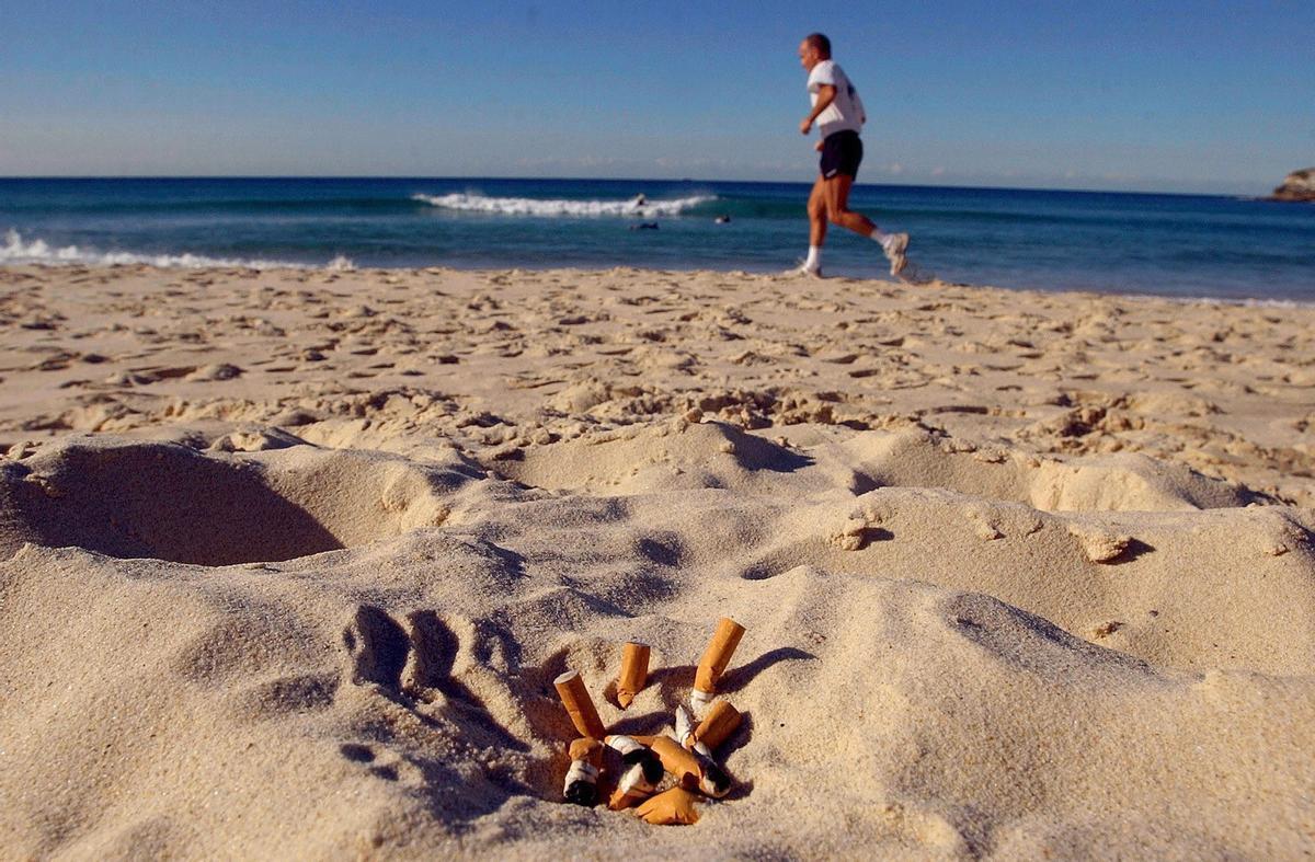 Varias colillas apagadas sobre la arena en una playa acabarán en el fondo del mar.