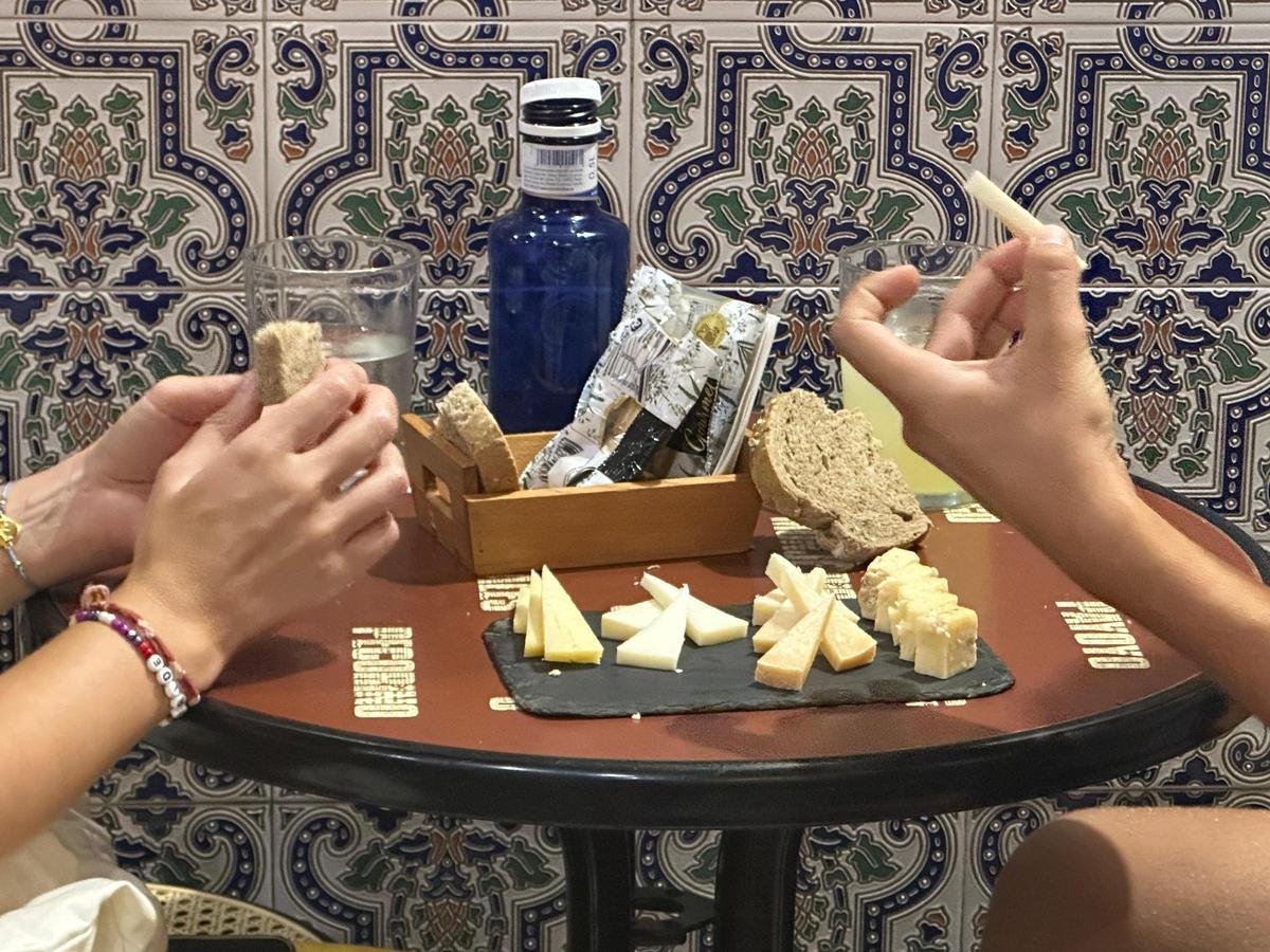 Clientes pruebas una tabla de queso 'a medida' del Bar Juan Carlos, en Triana.