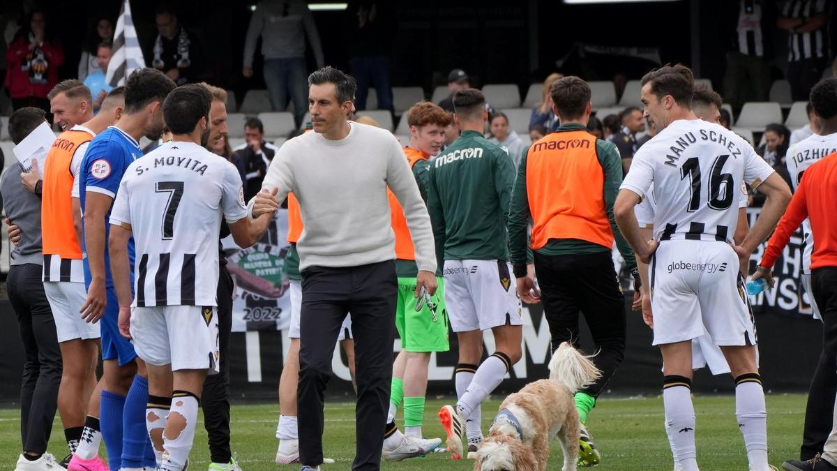 Voulgaris felicita a Moyita tras un partido, con el perro Oscar a su vera.