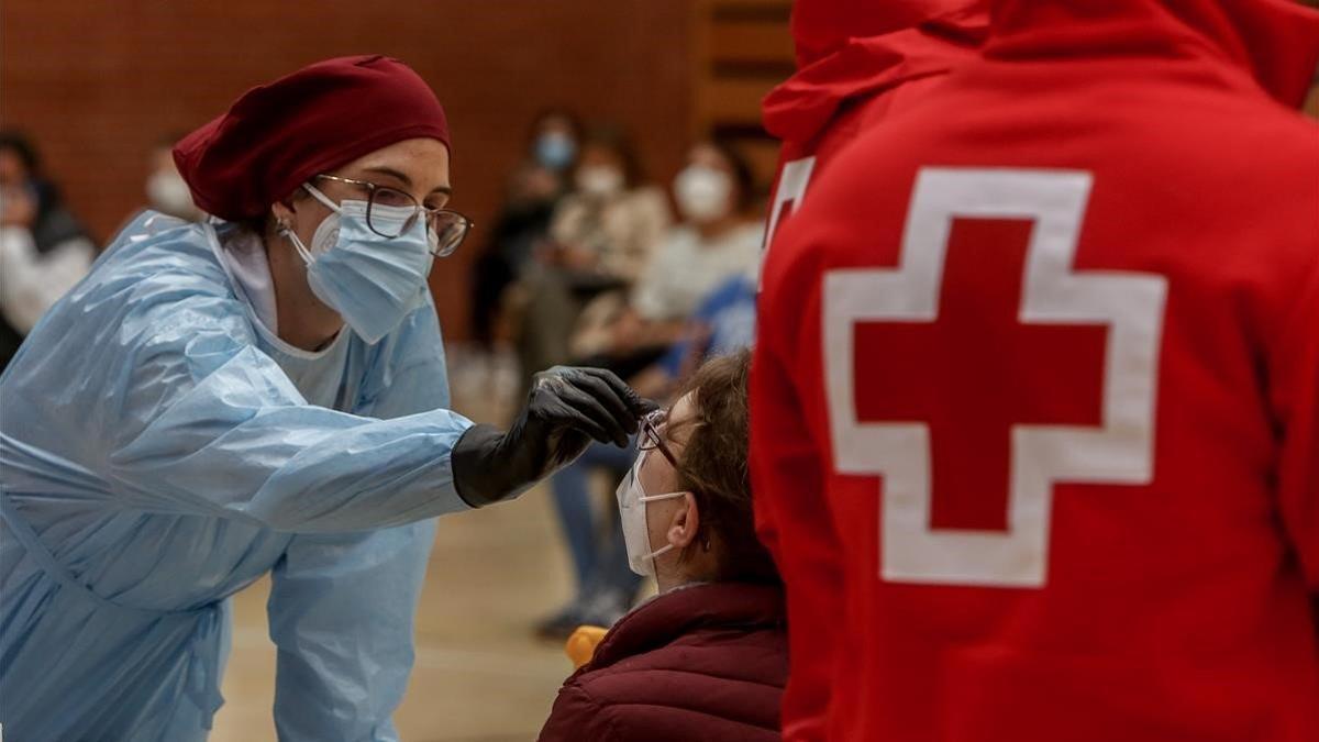 Una sanitaria realiza un test de antígenos para la detección del coronavirus a una mujer en el polideportivo municipal El Torreón, en Pozuelo de Alarcón (Madrid), el 3 de noviembre del 2020