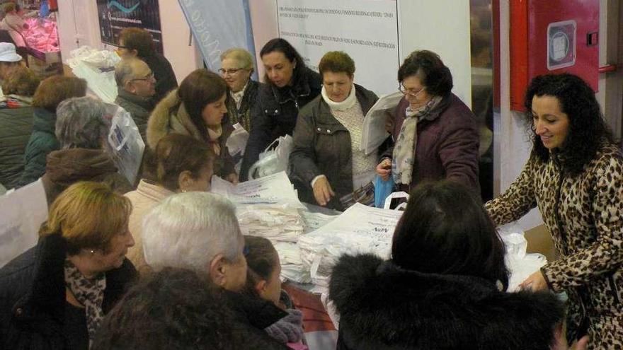 Reparto de bolsas conmemorativas, ayer en la plaza de abastos de Marín. // S.Álvarez