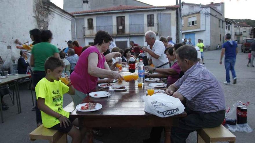 En la imagen de la izquierda, los vecinos de Valer degustan la ternera alistana hecha a la brasa junto al río, como se puede ver en la imagen de la derecha.