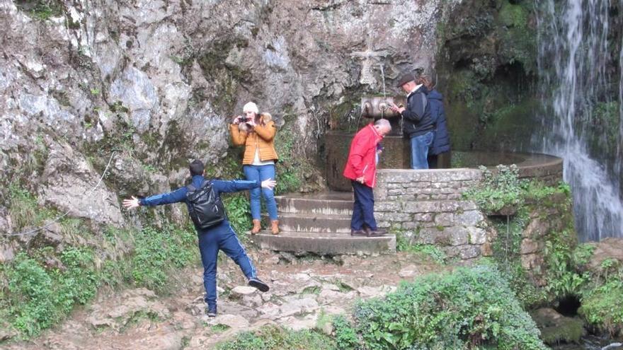 Turistas, al mediodía de ayer, en la fuente de los siete caños, bajo la cueva de Covadonga.