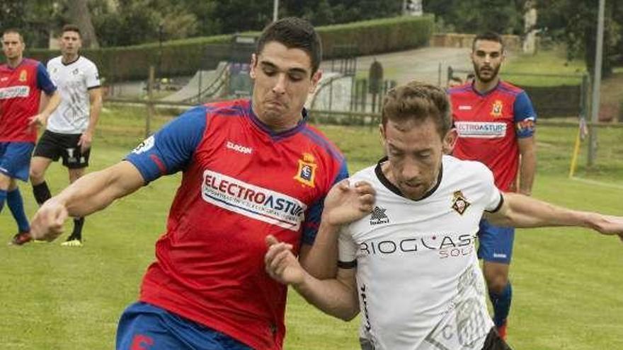 El jugador del Condal Domínguez, a la izquierda, pelea un balón con Robert, del Caudal, ayer, en el Alejandro Ortea.