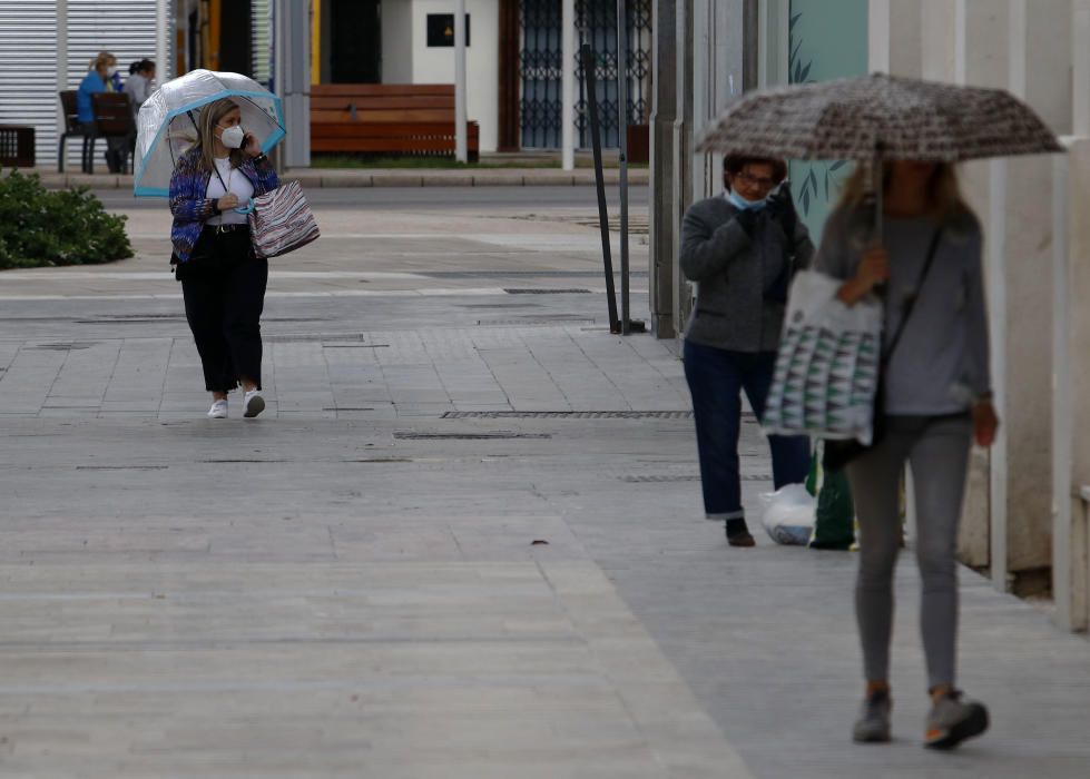 Imágenes de una lluviosa mañana de jueves en el centro de Málaga, donde al paisaje ya habitual de pocas personas y la mayoría de ellas con guantes y mascarillas se le han añadido los preparativos de bares, cafeterías y terrazas que se preparan para el inminente cambio de fase de la desescalada de la ciudad.