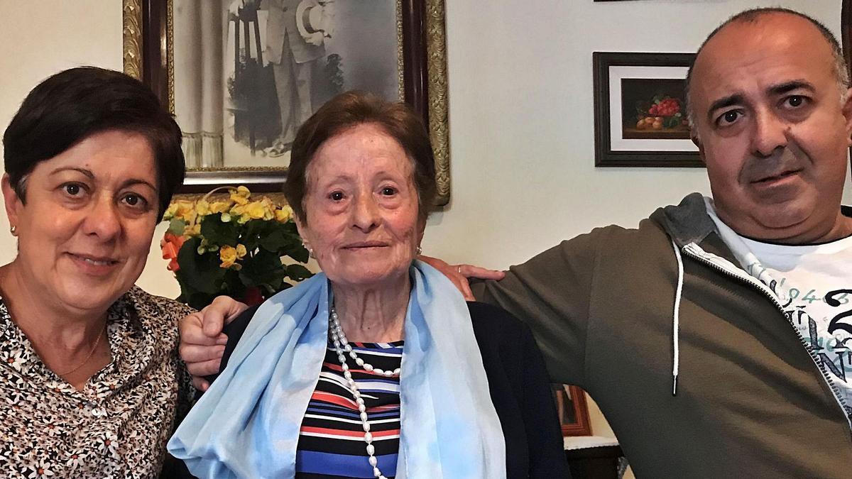 Consuelo Gutiérrez, de 95 años, y sus hijos Consuelo y Carlos, junto a varios retratos de Román García, Consuelo y su familia.