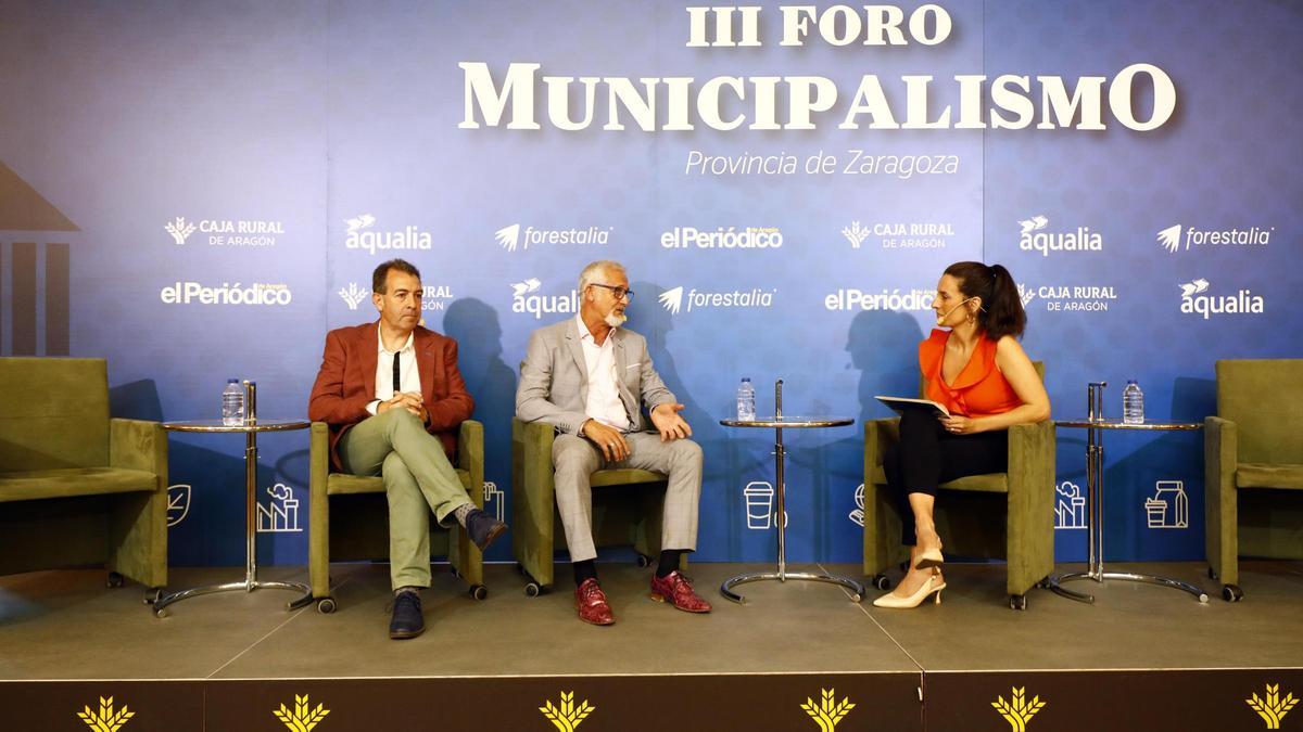 El presidente de la Comarca Campo de Belchite, Carmelo Pérez y el presidente de la Comarca Central, Miguel Ángel Ezquerra, junto a la moderadora y periodista Laura Rabanaque.