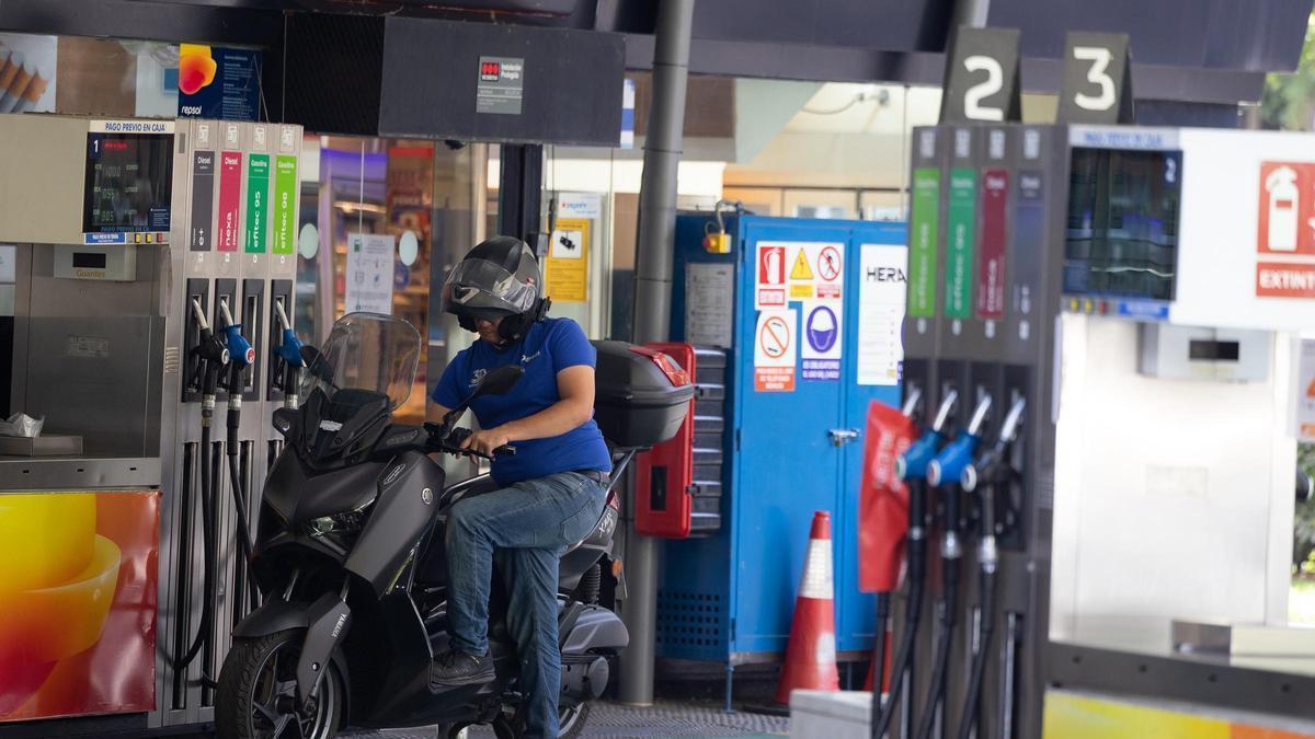 Un motorista a punto de repostar en una gasolinera. Los carburantes siguen su escalada.