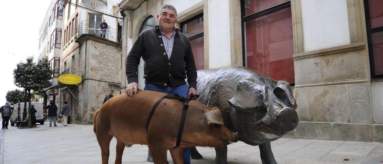 Manuel Dobalo y su cerdo Queitano junto al monumento al cerdo de Lalín.