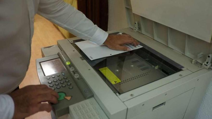 Un oficinista saca la fotocopia de un documento en una máquina fotocopiadora.