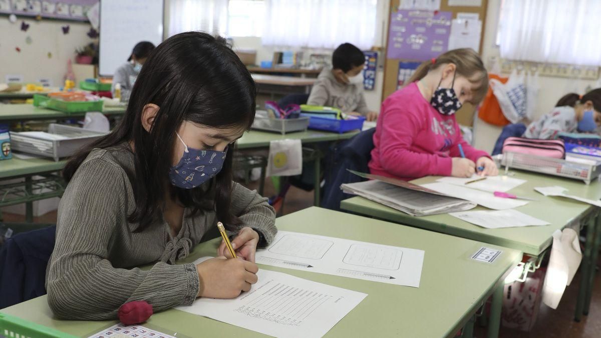 Alumnos con mascarillas en un aula.
