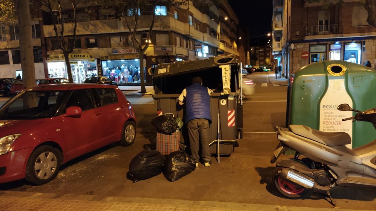 Un señor busca en un contenedor en Zamora capital.