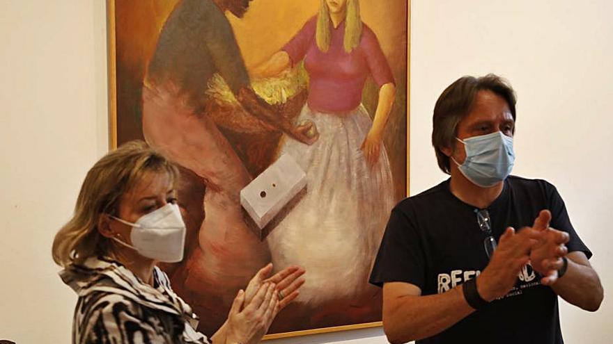 El cuadro “Razas” fue donado por el difunto pintor Julio Magdalena a Accem. En la imagen, Julia Magdalena, una de las hijas del pintor, y Javier Mahia, ante la obra, en la Fundación Alvargonzález.