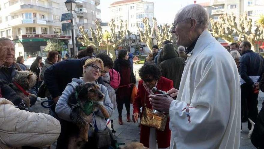 El sacerdote bendice a varios perros. // Noé Parga