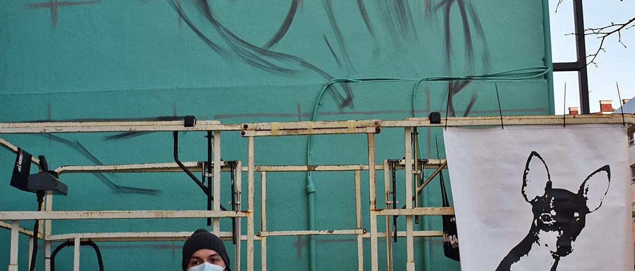 Ángel Caballero, alias “Xolaka”, ante la pared lateral del edificio de Lugones que está pintando. | A. I.