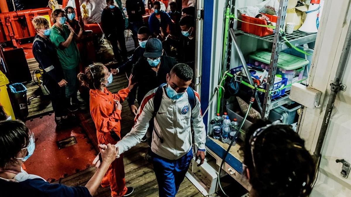 Un grupo de inmigrantes rescatados en el mar desembarcan en el puerto italiano de Porto Empedocle.