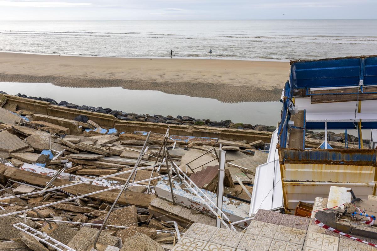 Mariscadores faenando en la playa de Matalascañas con los escombros en primer plano.