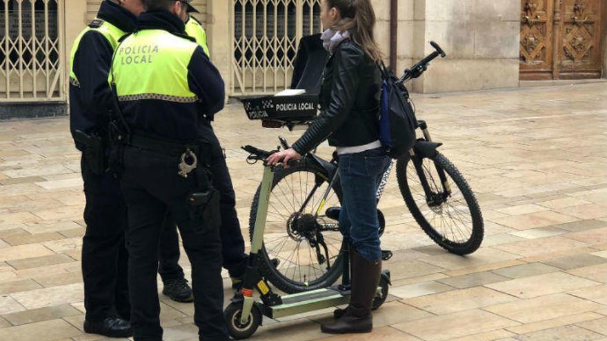 Policías de la brigada ciclista con una joven que iba en patinete en la zona de San Nicolás, ayer