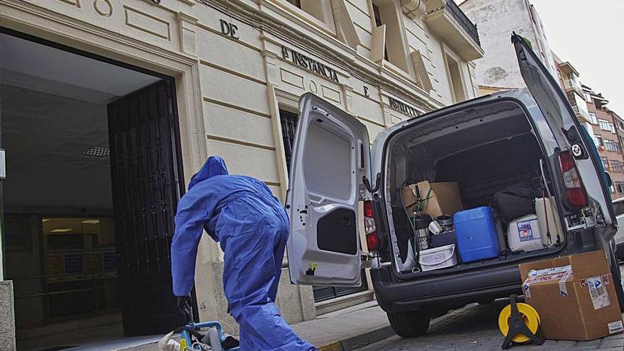 El operario de la empresa de desinfección entra en el Palacio de Justicia. | José Luis Fernández