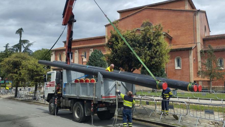 Un grupo de operarios, ayer, descargando tuberías. | M. Á. G.