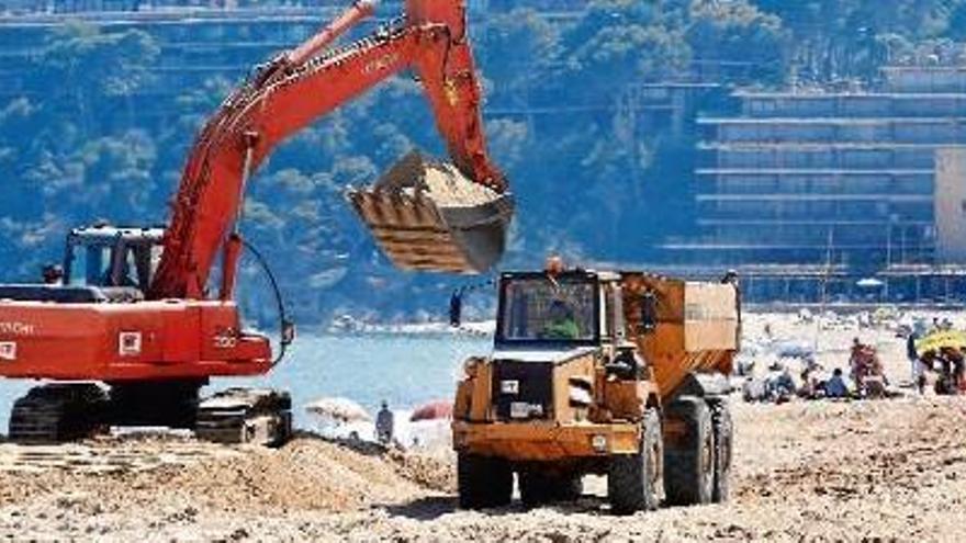 Maquinària pesant i banyistes a la platja