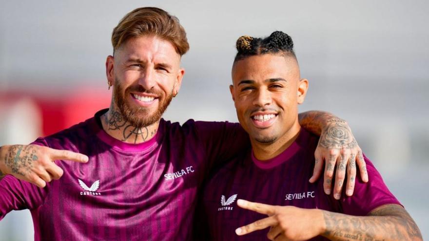 Sergio Ramos, a la izquierda, señala a Mariano Díaz, que hace un gesto de victoria con los dos dedos índice y corazón; ambos fueron compañeros en el Real Madrid. | | SEVILLA