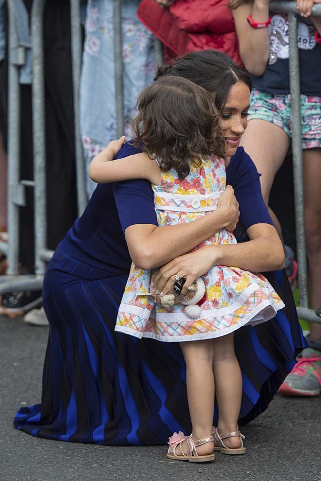 Meghan Markle abrazando a una niña en su tour por Oceanía