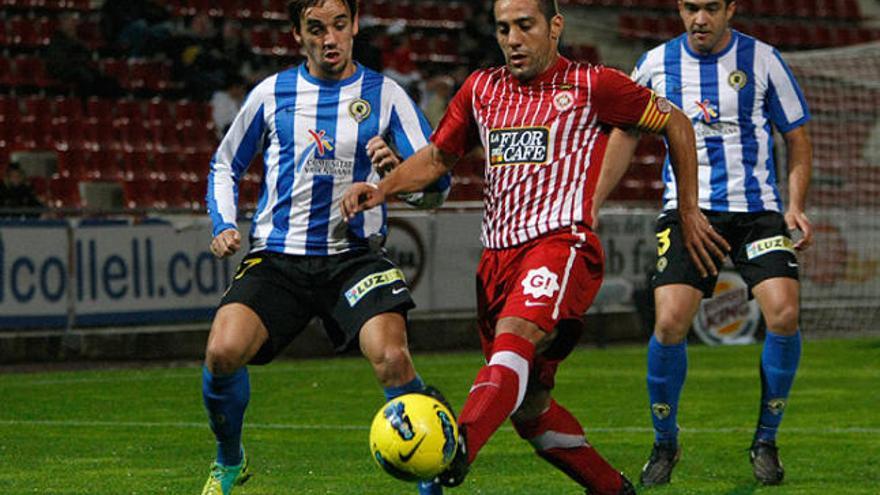 Moha controla la pilota davant la pressió d&#039;un futbolista de l&#039;Hèrcules.