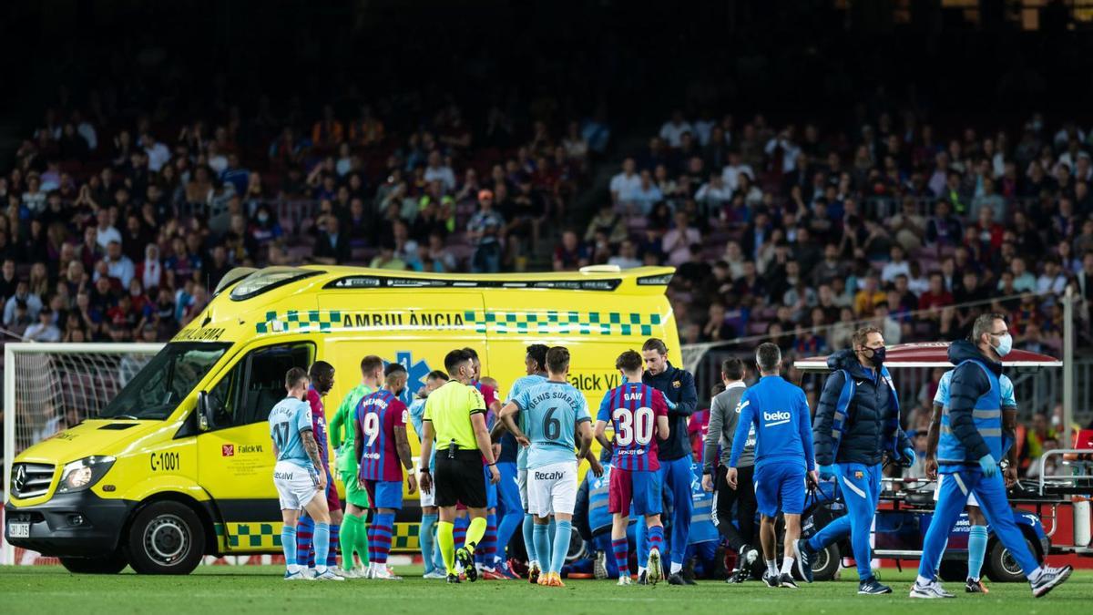 Los jugadores del Celta y Barcelona esperan a que la ambulancia se lleve a Ronald Araújo. // LOF