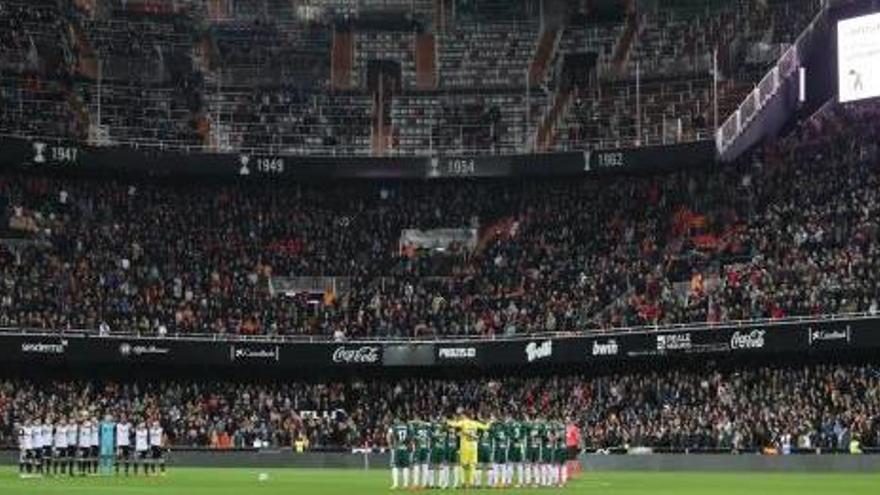 Los futbolistas de ambos equipos, durante el minuto de silencio.