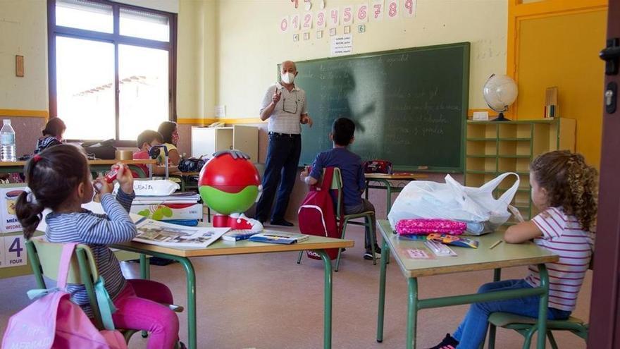Un maestro da clase a un grupo de Infantil en una escuela.
