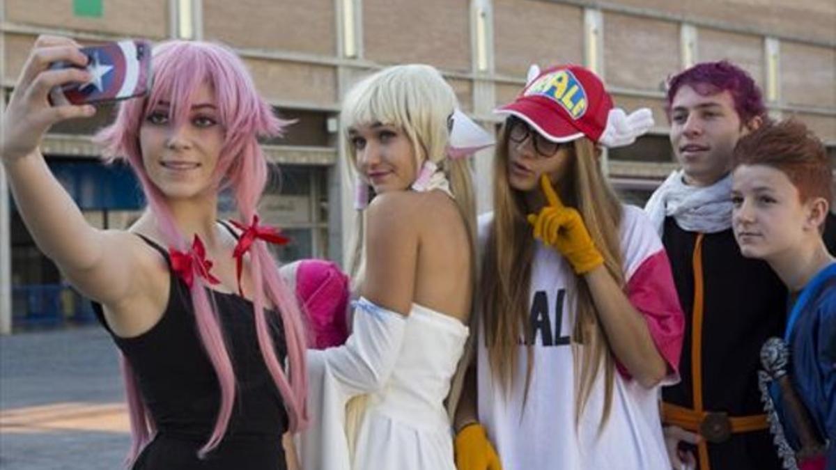 Cuatro jóvenes visitantes practican el 'cosplay' y el selfi, en la 21ª edición del Salón del Manga de Barcelona.