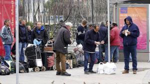 Un grupo de sintecho esperan ante Ifema la apertura del pabellon habilitado para personas sin vivienda mientras dure el confinamiento, el 20 de marzo.