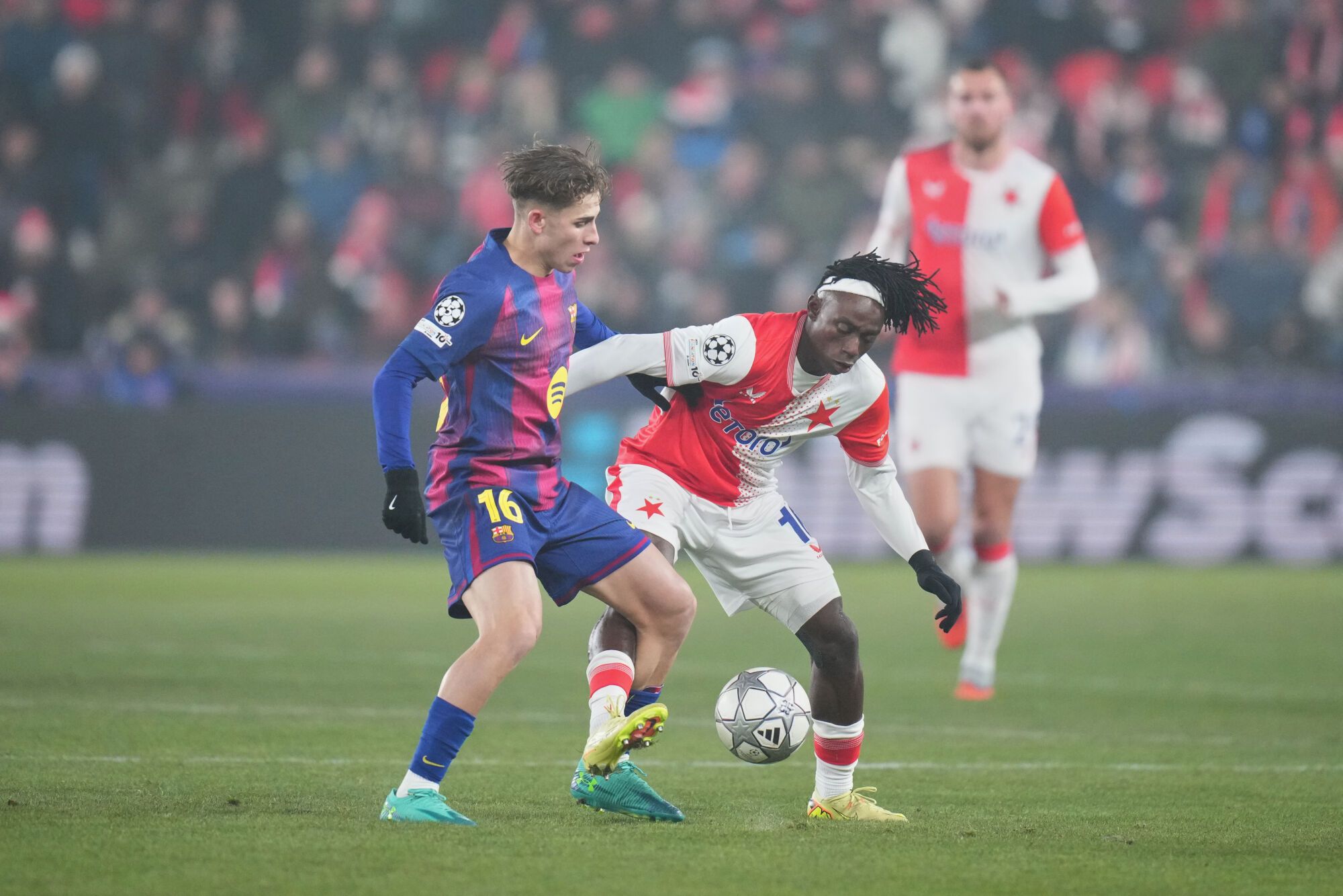 Slavia's David Moses, right, is challenged by Barcelona's Fermin Lopez during the Champions League opening phase soccer match between Slavia Prague and Barcelona in Prague, Czech Republic, Wednesday, Jan. 21, 2026. (AP Photo/Petr David Josek)
