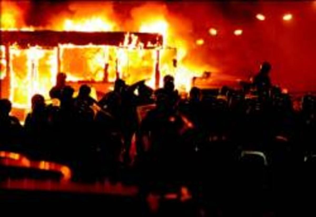 Policies antidisturbis, davant d’un bus incendiat per manifestants contraris a l’abocador de Pianura, ahir a la nit.