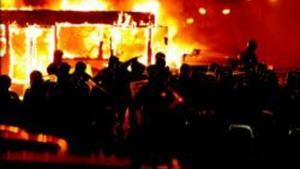 Policies antidisturbis, davant d’un bus incendiat per manifestants contraris a l’abocador de Pianura, ahir a la nit.