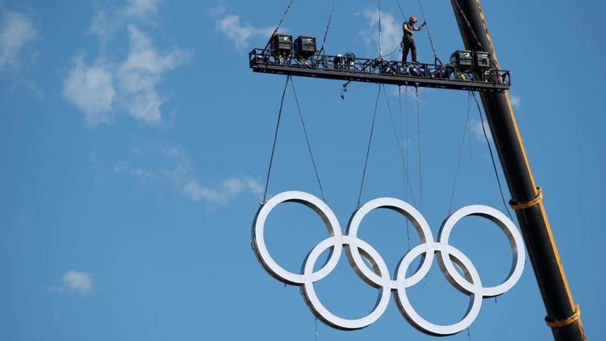 Unas grúas levantan los anillos olímpicos en la zona del Obelisco este viernes.