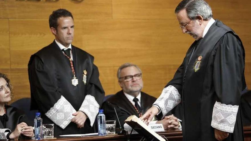 Luis Albo Aguirre jura el cargo ante la mirada del decano saliente, Ignacio Cuesta (de pie).