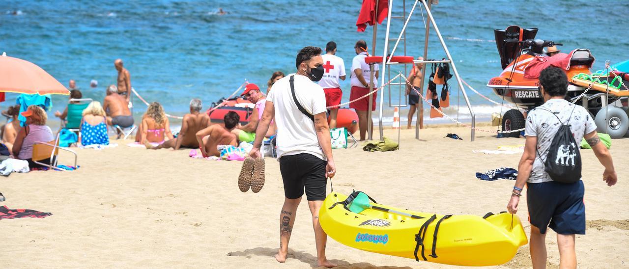 Un hombre con mascarilla en una playa