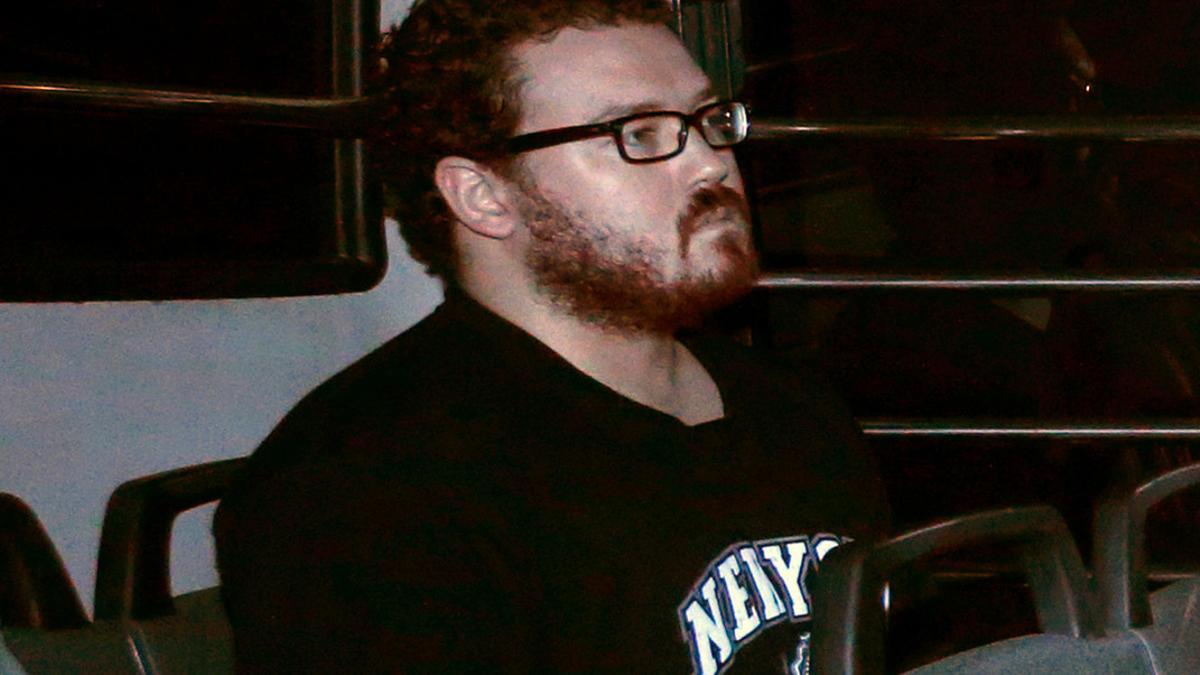 File photo of Jutting, a British banker charged with two counts of murder, sitting in the back row of a prison bus as he arrives at the Eastern Law Courts in Hong Kong