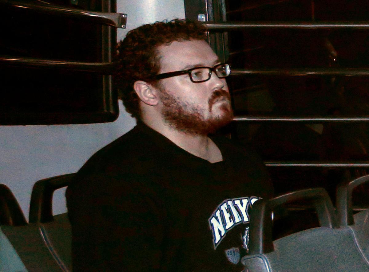 File photo of Rurik George Caton Jutting, a British banker charged with two counts of murder after police found the bodies of two women in his apartment, sitting in the back row of a prison bus as he arrives at the Eastern Law Courts in Hong Kong November 24, 2014. REUTERS/Bobby Yip/File Photo
