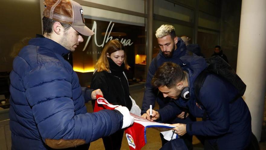 Traver y Álvaro Vázquez firman una camiseta a dos aficionados del Sporting.