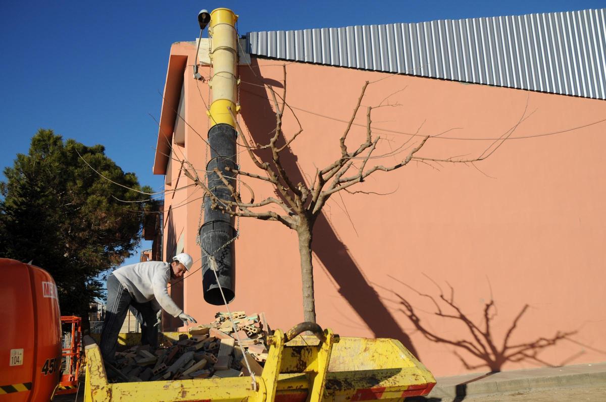 Un operari retirant les plaques que es van desprendre de la teulada de l'escola aquell gener del 2009