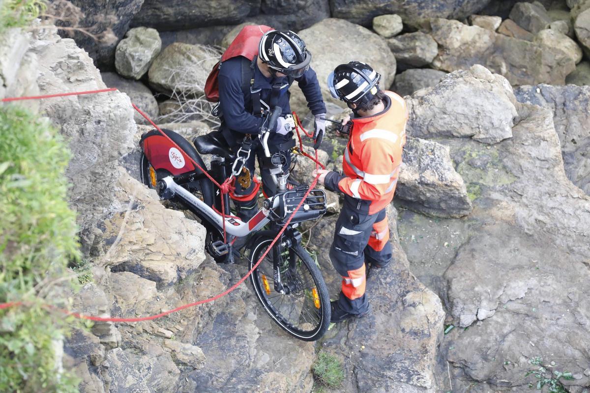 Bomberos recuperando una bicicleta de alquiler municipal.