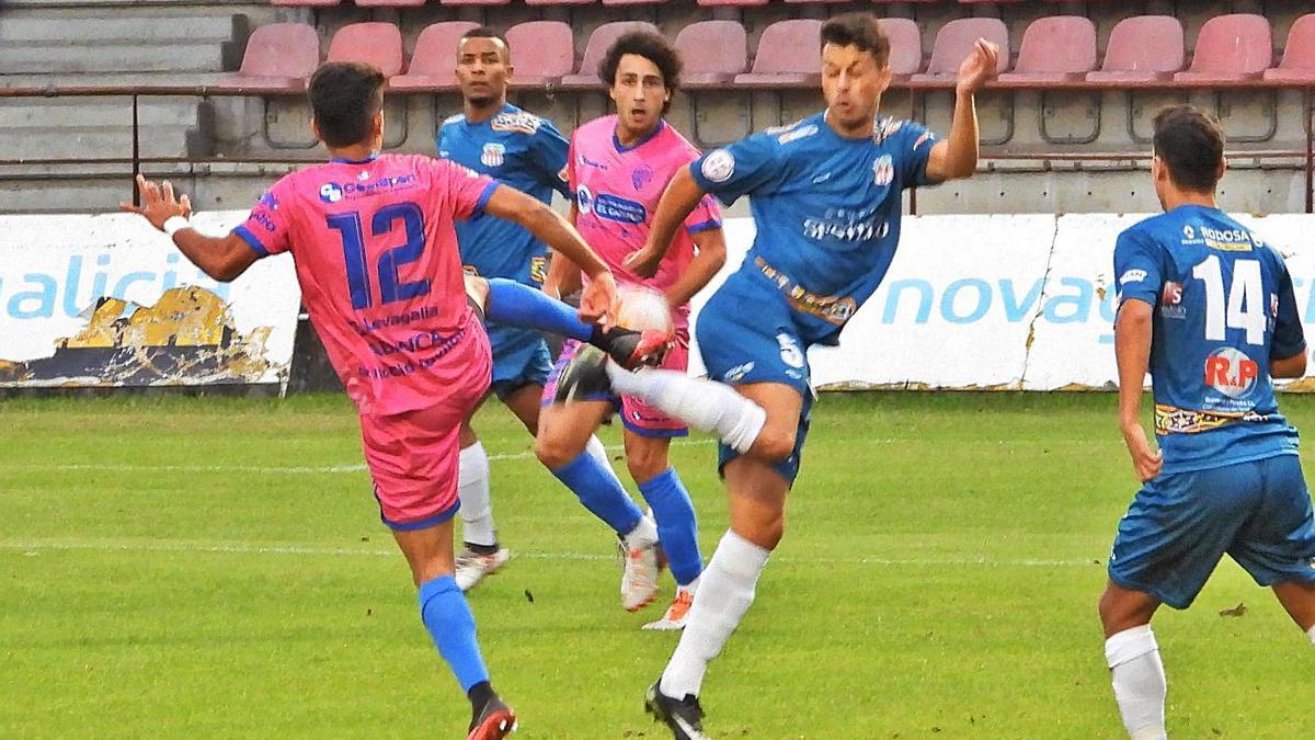 Un jugador del Ourense CF y otro del Juvenil luchan por el control del balón. |  // FERNANDO CASANOVA