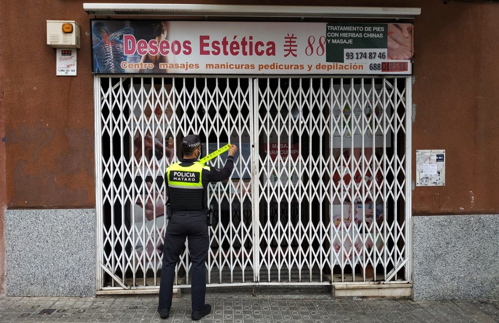 Un agente de la Policía Local de Mataró clausura un local de belleza de la ciudad.
