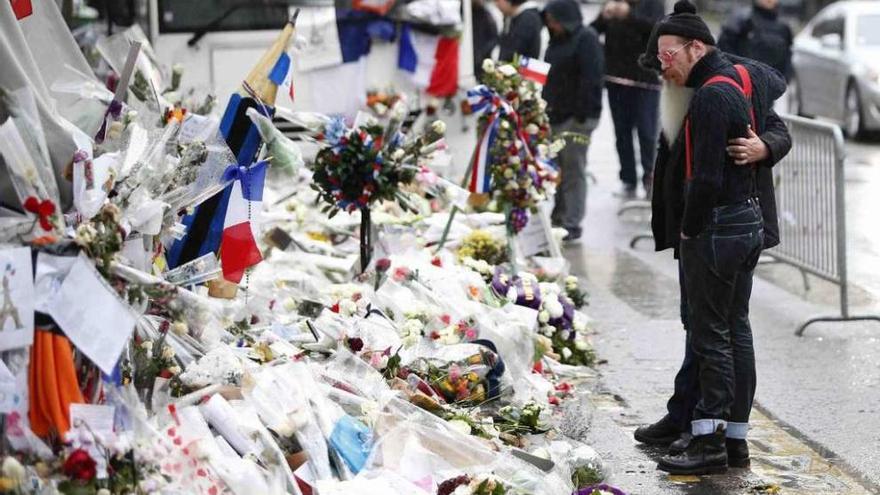 Miembros de Eagles of Death Metal depositan flores frente a la puerta de la sala Bataclan.