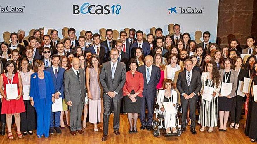 Fotografía de familia de los Reyes con los jóvenes becados por La Caixa.