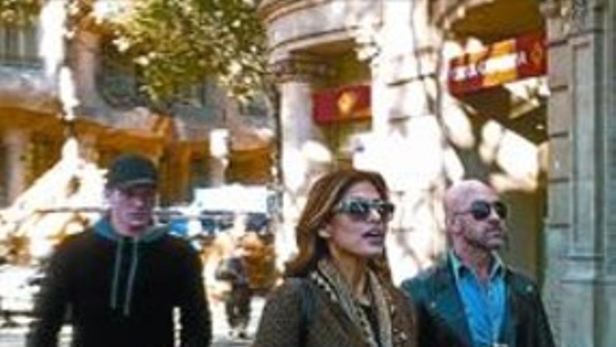 Eva Mendes, ayer, en el restaurante L'Escamarlà, a la hora de la comida. A la derecha, la actriz, en el paseo de Gràcia, justo a la altura de la Pedrera (a su espalda).